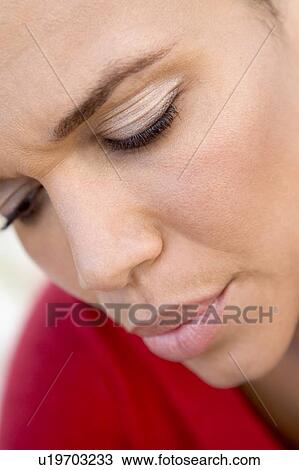 Stock Image - Head shot of woman scowling. Fotosearch