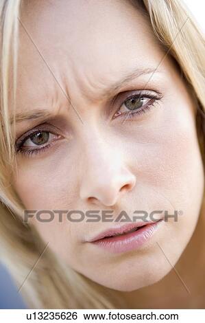 Stock Photograph - Head shot of woman scowling. Fotosearch