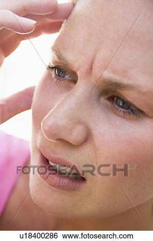 Stock Photograph - Head shot of woman scowling. Fotosearch