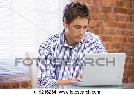 Businessman in office typing on laptop View Large Photo Image Picture - Businessman in office typing on laptop. Fotosearch
