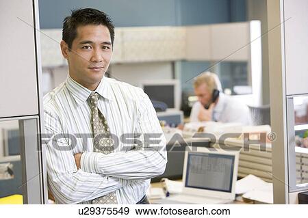 Stock Photo - Businessman standing in cubicle. Fotosearch