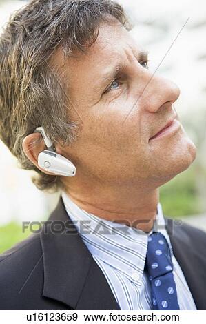 Stock Photo - Businessman wearing headset outdoors. Fotosearch