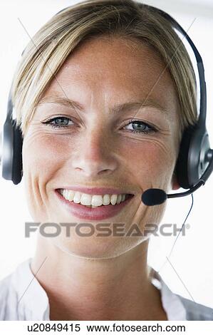 Stock Photography - Businesswoman in office wearing headset and smiling. Fotosearch
