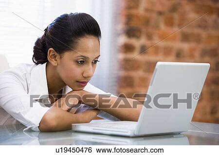 Businesswoman in office with laptop View Large Photo Image Stock Photograph - Businesswoman in office with laptop. Fotosearch