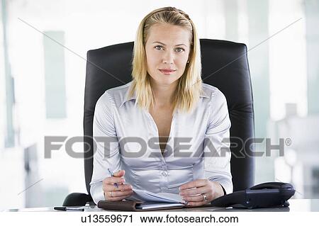 Businesswoman sitting in office with personal organizer View Large Photo Image Stock Image - Businesswoman sitting in office with personal organizer. Fotosearch