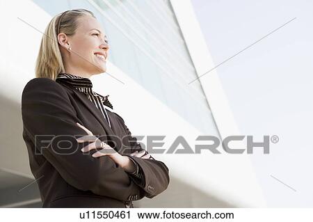 Businesswoman standing outdoors by building smiling View Large Photo Image Stock Image - Businesswoman standing outdoors by building smiling. Fotosearch