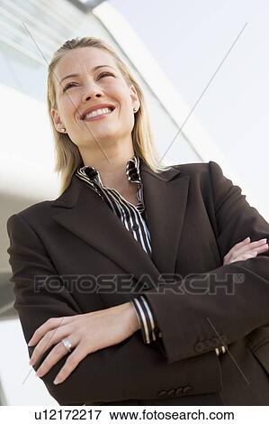 Businesswoman standing outdoors by building smiling View Large Photo Image Stock Photo - Businesswoman standing outdoors by building smiling. Fotosearch