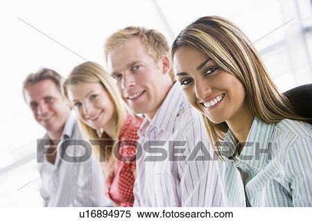 Four businesspeople sitting indoors smiling View Large Photo Image Stock Photography - Four businesspeople sitting indoors smiling. Fotosearch