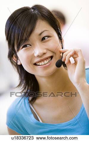Woman wearing headset indoors smiling View Large Photo Image Stock Image - Woman wearing headset indoors smiling. Fotosearch