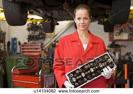 Mechanic holding car part smiling View Large Photo Image Stock Image - Mechanic holding car part smiling. Fotosearch
