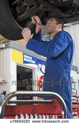 Mechanic working under car View Large Photo Image Stock Image - Mechanic working under car. Fotosearch