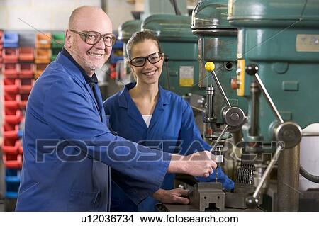 Picture - Two machinists working on machine. Fotosearch