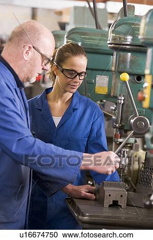 Stock Image - Two machinists working on machine. Fotosearch