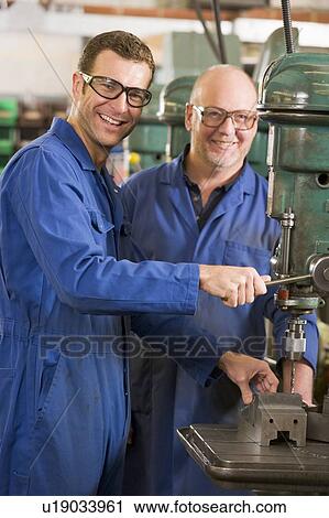 Two machinists working on machine View Large Photo Image Stock Image - Two machinists working on machine. Fotosearch