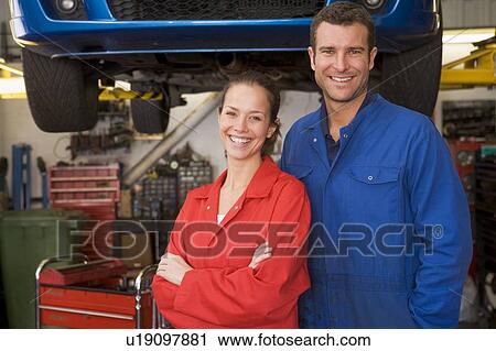 Two mechanics standing in garage smiling View Large Photo Image Stock Image - Two mechanics standing in garage smiling. Fotosearch