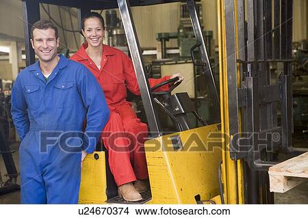 Two warehouse workers with forklift View Large Photo Image Picture - Two warehouse workers with forklift. Fotosearch
