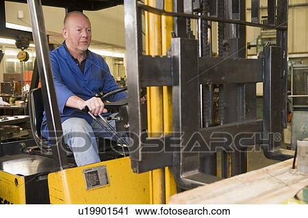 Stock Image - Warehouse worker in forklift. Fotosearch