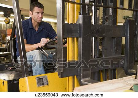 Stock Image - Warehouse worker in forklift. Fotosearch