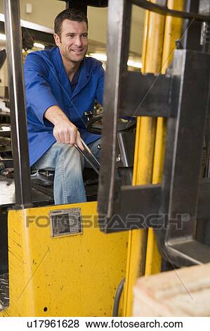 Warehouse worker in forklift View Large Photo Image Stock Photo - Warehouse worker in forklift. Fotosearch
