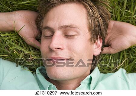 Man lying on grass sleeping View Large Photo Image Stock Photo - Man lying on grass sleeping. Fotosearch