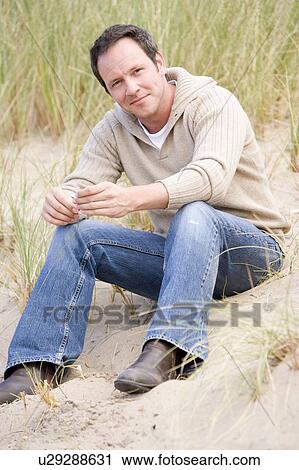 Man sitting on beach View Large Photo Image Stock Image - Man sitting on beach. Fotosearch
