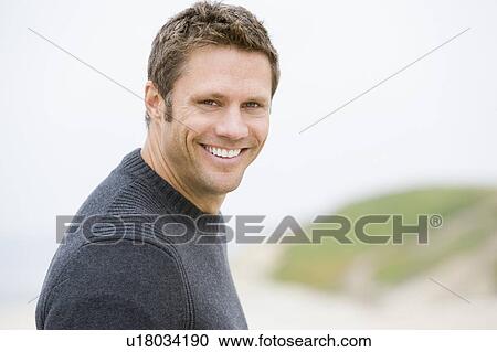 Man standing at beach smiling View Large Photo Image Stock Image - Man standing at beach smiling. Fotosearch