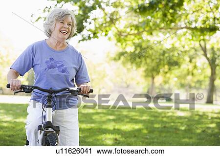 Senior woman on a bicycle View Large Photo Image Stock Image - Senior woman on a bicycle. Fotosearch