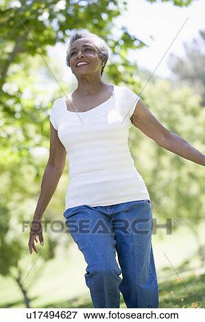 Stock Photo - Senior woman walking in park. Fotosearch