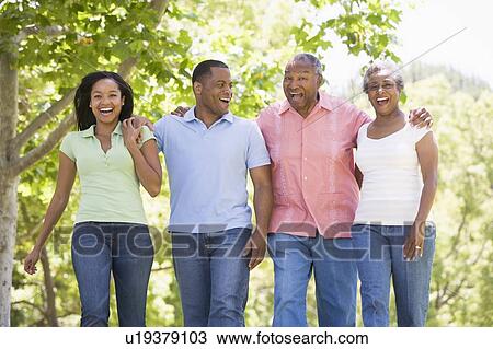 Two couples walking outdoors arm in arm smiling View Large Photo Image Stock Image - Two couples walking outdoors arm in arm smiling. Fotosearch