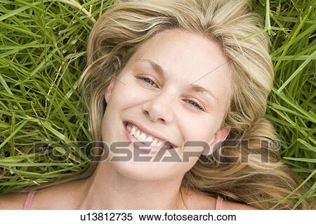 Woman lying on grass View Large Photo Image Stock Photography - Woman lying on grass. Fotosearch