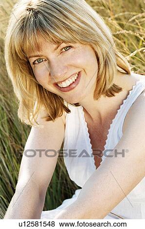 Stock Photo - Woman sitting outdoors smiling. Fotosearch