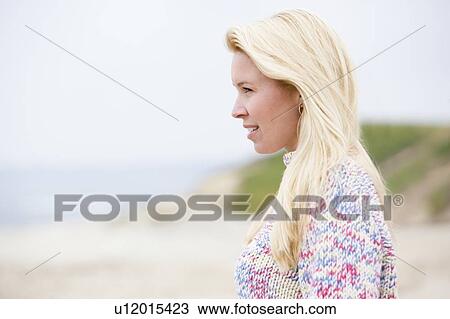 Stock Image - Woman standing at beach. Fotosearch