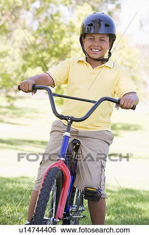 Young boy on bicycle outdoors smiling View Large Photo Image Stock Photograph - Young boy on bicycle outdoors smiling. Fotosearch