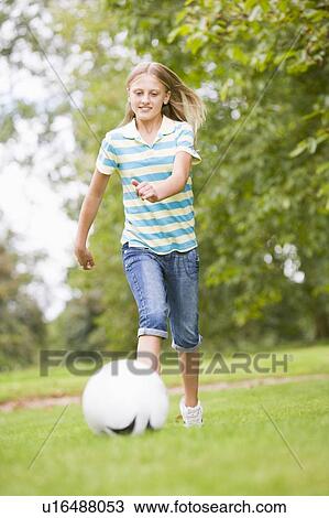 Stock Image - Young girl playing soccer. Fotosearch