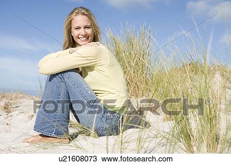 Stock Image - Young woman posing on a sand hill. Fotosearch