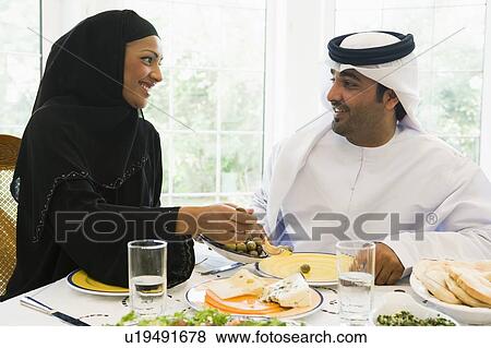 Couple sitting at dinner table smiling (high key) View Large Photo Image Stock Photo - Couple sitting at dinner table smiling (high key). Fotosearch