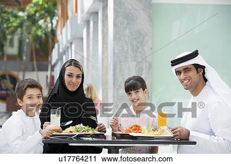 Family at restaurant eating and smiling (selective focus) View Large Photo Image Stock Image - Family at restaurant eating and smiling (selective focus). Fotosearch