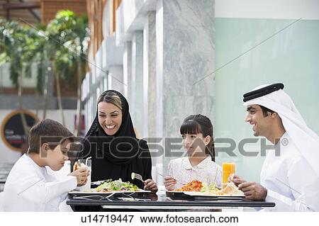 Family at restaurant eating and smiling (selective focus) View Large Photo Image Stock Photo - Family at restaurant eating and smiling (selective focus). Fotosearch