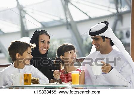 Family at restaurant eating dessert and smiling (selective focus) View Large Photo Image Stock Photography - Family at restaurant eating dessert and smiling (selective focus). Fotosearch