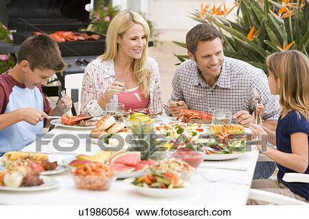 Picture - Family Enjoying A Barbeque. Fotosearch