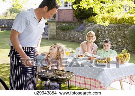 Picture - Family Enjoying A Barbeque. Fotosearch