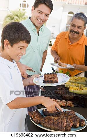 Stock Image - Family Enjoying A Barbeque. Fotosearch