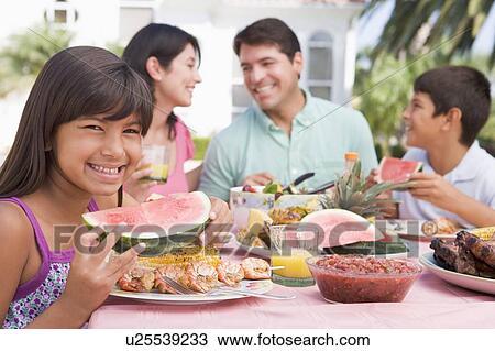 Stock Image - Family Enjoying A Barbeque. Fotosearch