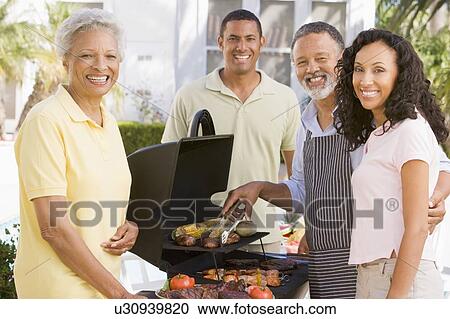 Stock Image - Family Enjoying A Barbeque. Fotosearch