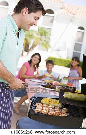 Stock Photo - Family Enjoying A Barbeque. Fotosearch
