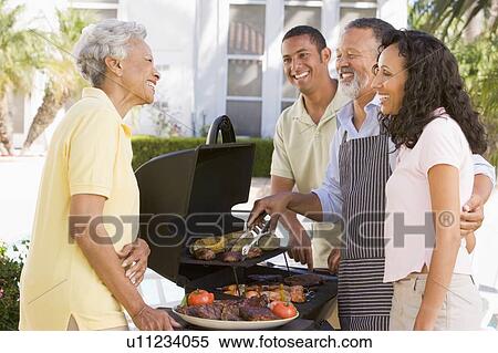 Stock Photography - Family Enjoying A Barbeque. Fotosearch