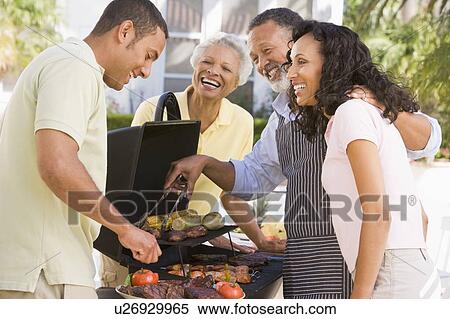 Stock Photography - Family Enjoying A Barbeque. Fotosearch