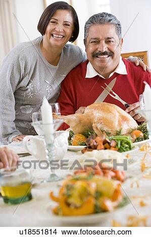 Woman With Her Arm Around Her Husband, Who Is Getting Ready To Carve A Turkey View Large Photo Image Picture - Woman With Her Arm Around Her Husband, Who Is Getting Ready To Carve A Turkey. Fotosearch