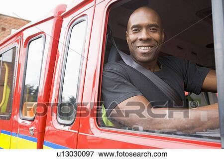 Fireman sitting in fire engine looking out window View Large Photo Image Stock Photo - Fireman sitting in fire engine looking out window. Fotosearch