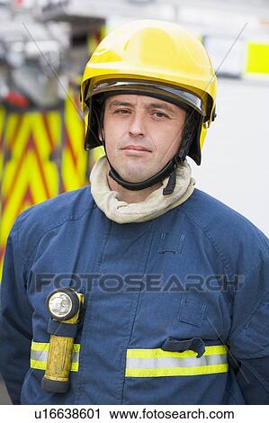 Fireman standing by fire engine wearing helmet View Large Photo Image Stock Image - Fireman standing by fire engine wearing helmet. Fotosearch